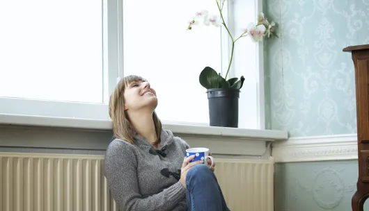Vrouw verwarmt zich bij radiator