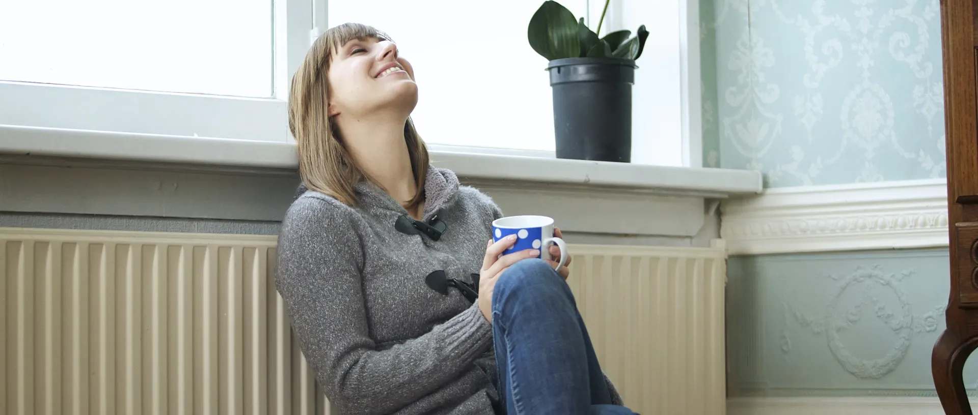 Vrouw verwarmt zich bij radiator