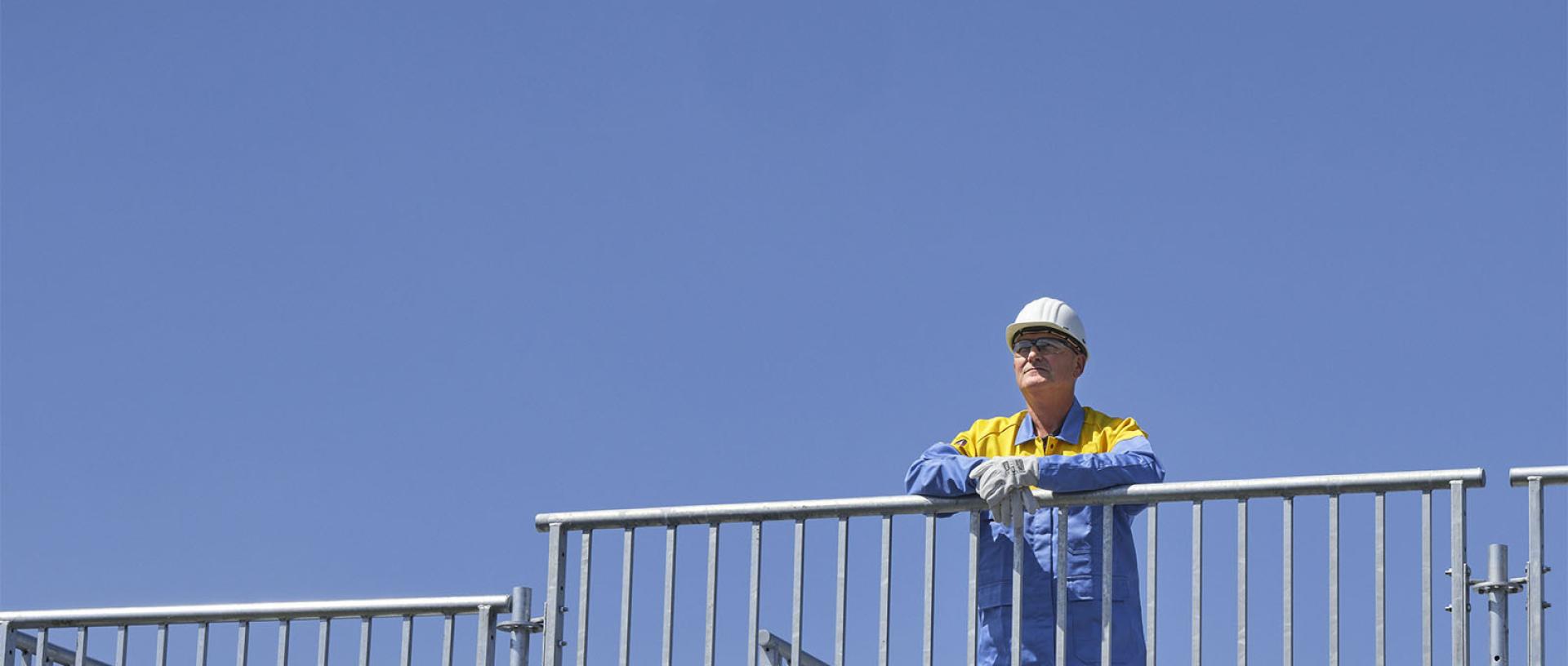 Man op steiger voor blauwe lucht